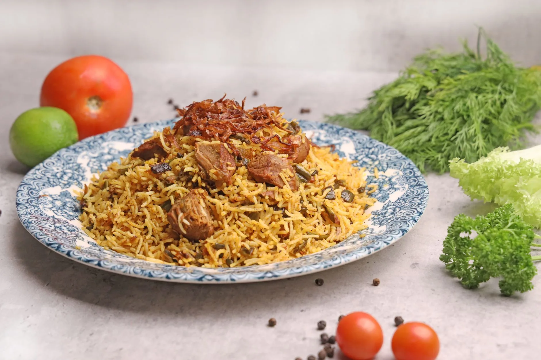 Plat de riz épicé à la viande et aux oignons frits, typique d'un repas de fête omanais